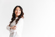 © Drobot Dean - Portrait of young asian woman with long dark hair looking aside at copyspace with arms crossed, isolated over white background in studio