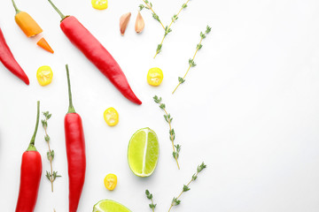 Composition with fresh chili peppers and herbs on white background