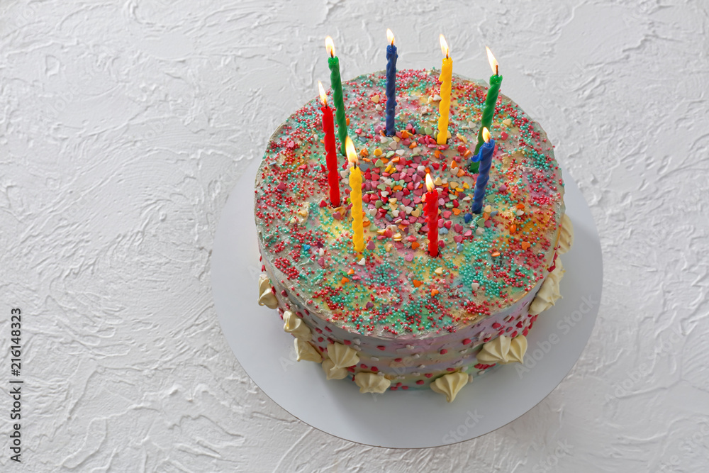 Beautiful tasty birthday cake with candles on white table