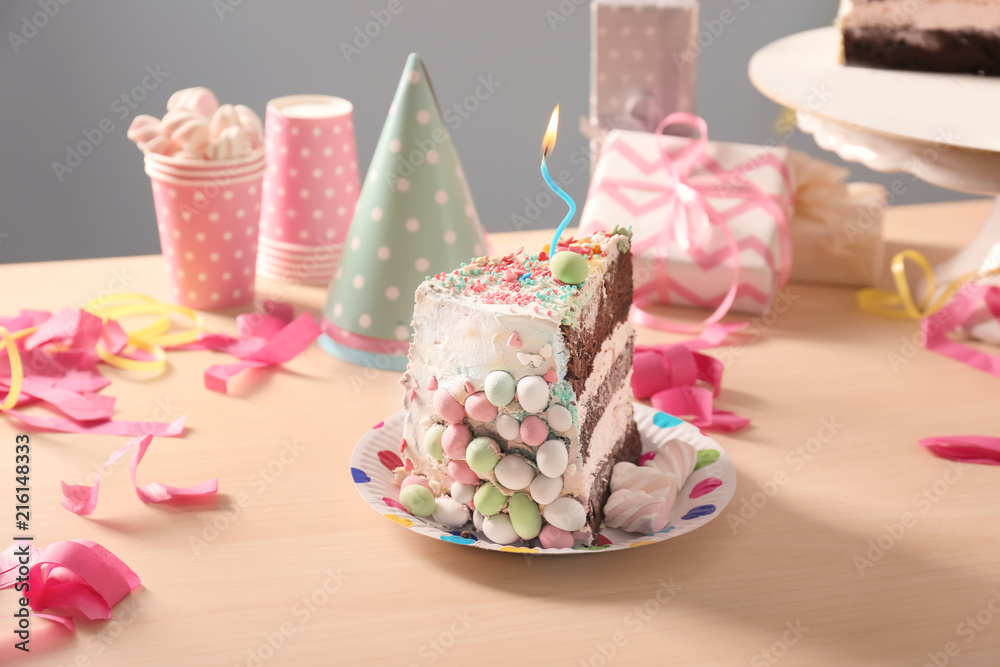 Plate with piece of tasty birthday cake on table