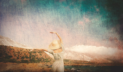 Caucasian girl in hat and white dress on sea coast in summertime. Stomio region, west Crete, Greece. Image in retro style