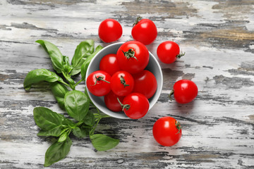 Bowl with fresh ripe cherry tomatoes on wooden background