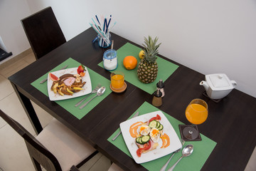 Healthy breakfast in kitchen. breakfast on table with omelet, sweet toasts, fruits and juice