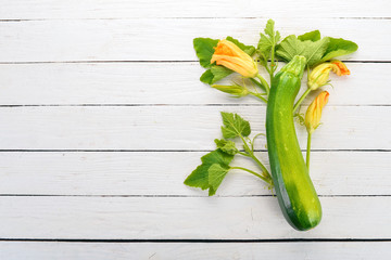 Fresh green zucchini on a white wooden table. Top view. Copy space.