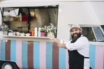 Portrait of a smiling food vendor with a food truk