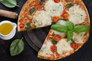 Close-up of italian traditional pizza with different types of cheese and tomatoes, view from above