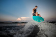 © fesenko - Active and strong man jumping on wakesurf down the river waves at the sunset