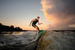 © fesenko - Active man wakesurfing down the river waves