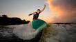 © fesenko - Handsome man wakesurfing down the river waves