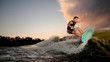 © fesenko - Handsome muscular young man wakesurfing down the river waves
