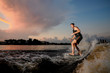 © fesenko - Young athletic man riding on wakesurf down the river during sunset