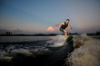 © fesenko - Handsome muscular man riding on wakesurf down the river during sunset