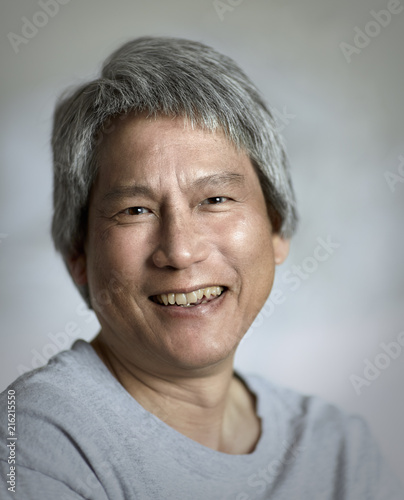 Asian Man With Gray Hair Looking Towards Camera And Smiling