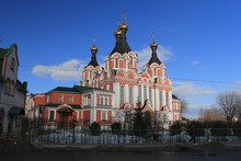 An Old White-orange Church With Small Dome-shaped Cupolas Against The Blue Sky