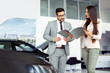 © zorandim75 - Two people talking about car contract in car salon