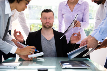 Wall Mural - Young Businessman Meditating In Office