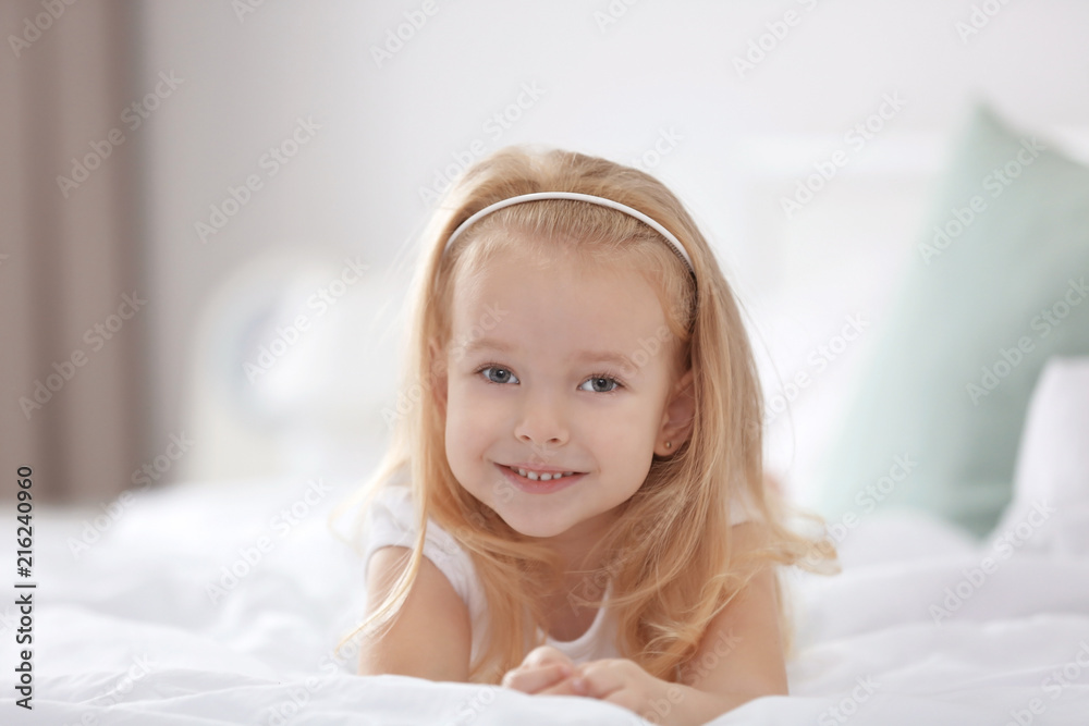 Little girl lying on bed at home