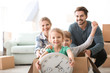 © Africa Studio - Young couple playing with children indoors. Happy family on moving day