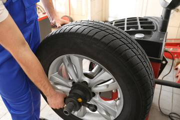 Wall Mural - Mechanic balancing wheel in service center. Seasonal tire change