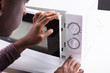 Man Pressing Button Of Microwave Oven