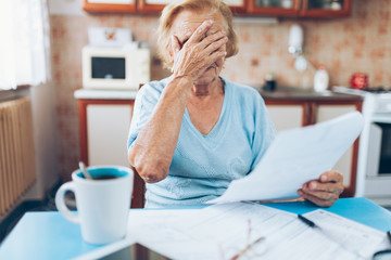 Elderly woman looking at her utility bills