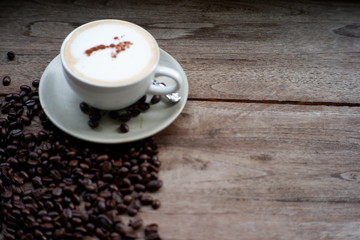 cappuccino coffee and coffee bean on old wood table