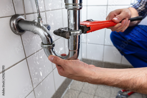 Fotomural Plumber Repairing Sink Pipe Leakage