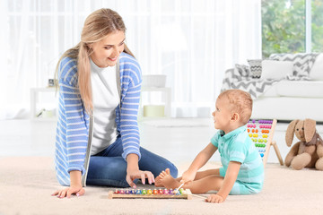 Canvas Print - Baby and mother playing with toy xylophone at home