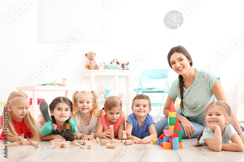 Fototapeta Cute little children playing with blocks in kindergarten