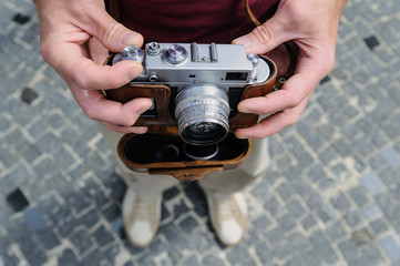 A man is holding a vintage camera.