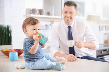 Canvas Print - Morning of cute baby boy and his dad in kitchen