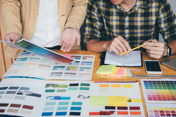 Poster - Young creative team having a meeting in creative office, Architectural drawing with work tools and accessories, Color swatch samples chart for selection coloring