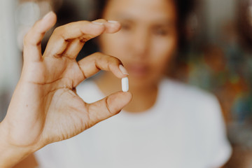 woman holding pills in one hand