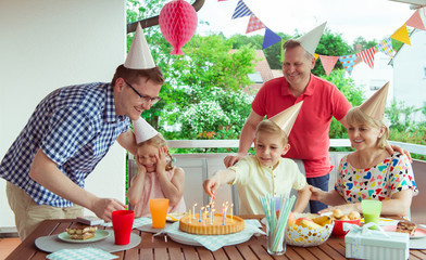 Wall Mural - Colorful portrait of happy family celebrate birthday and grandparents blows candles with their children