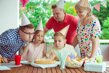 Wall Mural - Colorful portrait of happy family celebrate birthday and grandparents blows candles with children