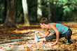 © Microgen - Woman stretching in the park, in the fall.
