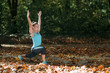 © Microgen - Woman stretching in the park, in the fall.