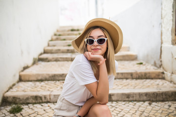 Wall Mural - Beautiful young caucasian woman smiling in urban background. Blond girl wearing casual clothes in the street.