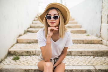 Wall Mural - Beautiful young caucasian woman smiling in urban background. Blond girl wearing casual clothes in the street.