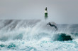Surfer jumping over a wave during a windy day