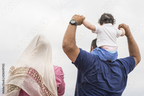 Fotografía Family group in front of cloudy sky backside view in outdoor