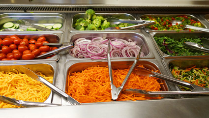 variety of colorful fresh vegetable salad in container in restaurant