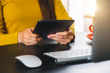 businesswoman hand using smart phone,tablet payments online shopping,omni channel,digital tablet docking keyboard computer at office in sun light