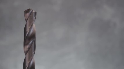 Poster - Metal drill bit rotation on a dark background. Macro view.