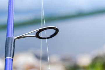 Wall Mural - Fishing rod spinning ring with the line close-up. Fishing rod. Fishing rod rings Selective focus and shallow Depth of field .Fishing tackle. Fishing spinning reel.