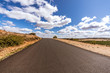 Views of an empty road in the middle of nowhere with a sky full of fantastic stratocumulus clouds. 