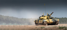 Military Or Army Tank Ready To Attack And Moving Over A Deserted Battle Field Terrain. A Lot Of Dust. Copyspace