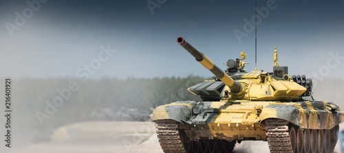 Tela Military or army tank ready to attack and moving over a deserted battle field terrain