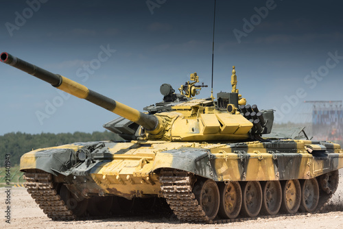 Fotomural Military or army tank ready to attack and moving over a deserted battle field terrain