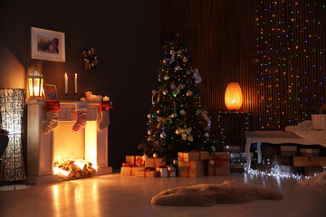 Stylish living room interior with decorated Christmas tree at night